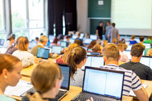 Studierende vor Computern in einem Klassenzimmer, alle lernen